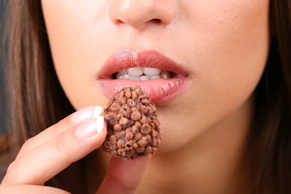 Primo piano della donna che mangia caramelle al cioccolato — Foto Stock