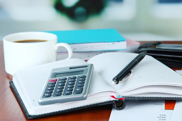 Materiały biurowe i filiżankę kawy na stole na jasnym tle — Zdjęcie stockowe