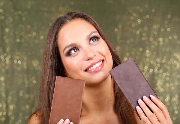 Portret van mooie jonge meisje met chocolade op glanzende achtergrond — Stockfoto