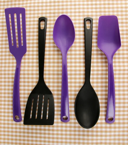 Plastic kitchen utensils on fabric background — Stock Photo, Image