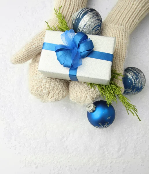 Manos femeninas en manoplas con caja de regalo, sobre fondo blanco —  Fotos de Stock