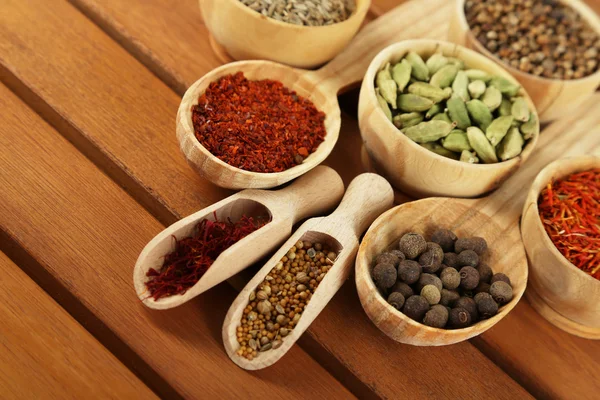 Många olika kryddor och doftande örter på träbord närbild — Stockfoto