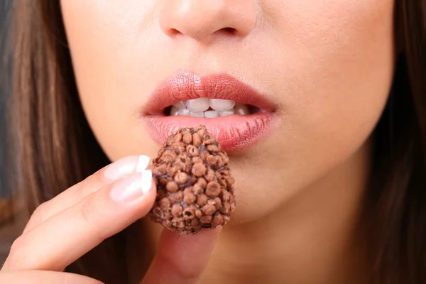 Closeup of woman eating chocolate candy Royalty Free Stock Images
