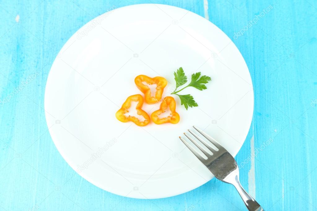 Small portion of food on big plate on wooden table close-up