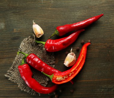 Red hot chili biber ve sarımsak, çul, ahşap zemin üzerinde