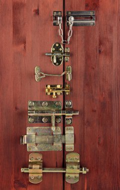 Metal bolts, latches and hooks in wooden door close-up clipart