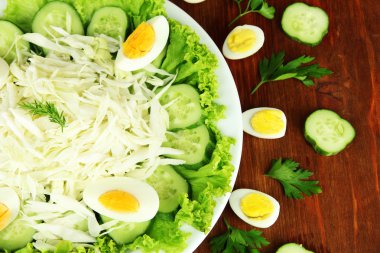 yumurta, lahana ve salatalık ahşap masa üstünde lezzetli salata