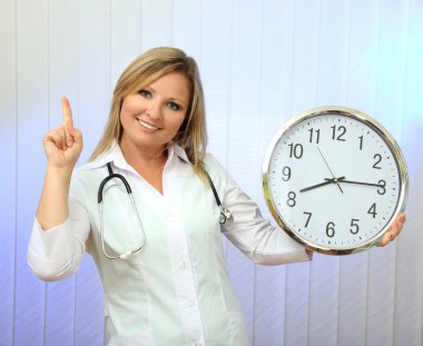 genç güzel doktor stetoskop ve saati, açık renkli