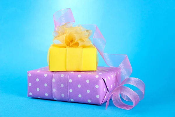 Bright gifts with bows on blue background — Stock Photo, Image