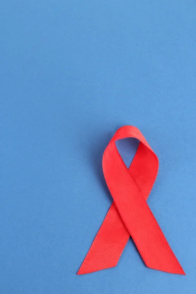 Red ribbon HIV, AIDS on blue background — Stock Photo, Image