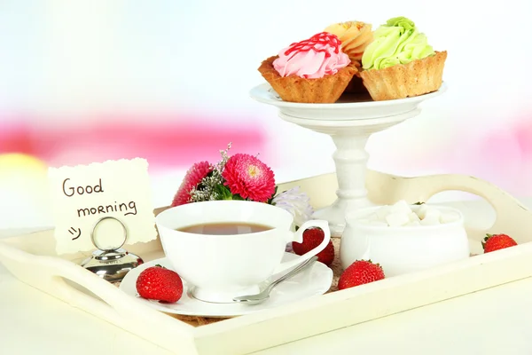 Tasse Tee mit Kuchen auf Holztablett auf dem Tisch im Zimmer — Stockfoto