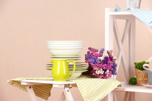 Vackra vita möbler med porslin och inredning, på färg vägg bakgrund — Stockfoto