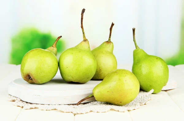Pears on wooden cutting board, on light background — Stock Photo, Image