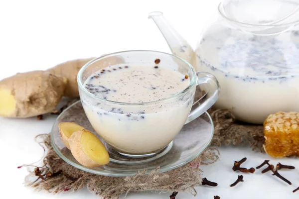 Bule e xícara de chá com leite e especiarias em pano de saco isolado em branco — Fotografia de Stock