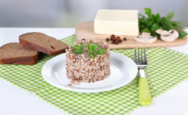 Гречка в тарелке с хлебом и маслом крупным планом — стоковое фото
