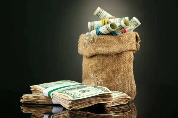 Dinero en bolsa sobre fondo de color oscuro — Foto de Stock