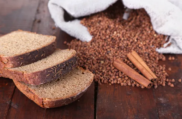 Tygpåse med bovete och bröd på trä bakgrund — Stockfoto