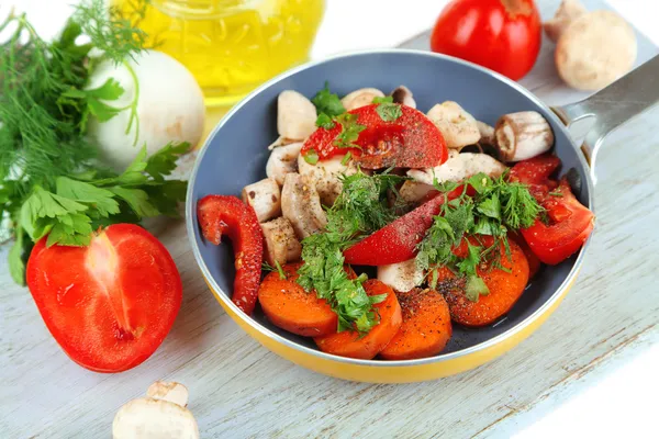 Verduras frescas en rodajas en sartén sobre tabla de madera aislada sobre blanco — Foto de Stock