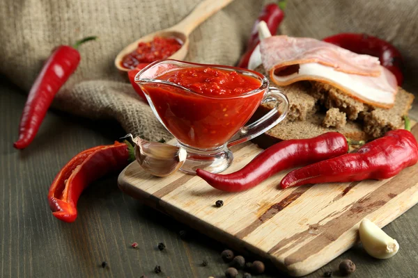 Složení s tomatovou salsou o chlebu,, red hot chili papričky a česnek na žíně, na dřevěné pozadí — Stock fotografie