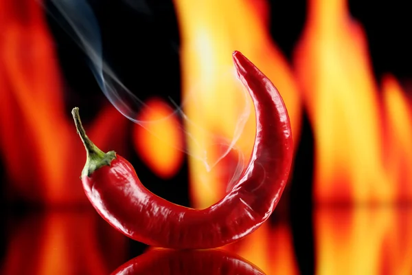 Pimiento rojo picante sobre fondo de fuego — Foto de Stock