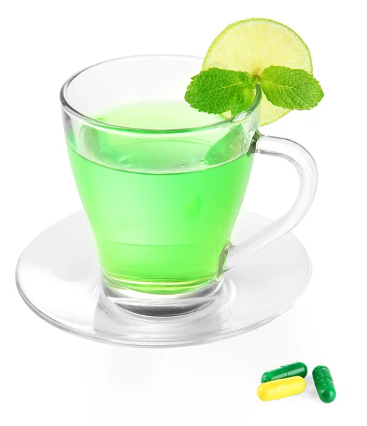 Tazza trasparente di tè verde e compresse isolate su bianco — Foto Stock