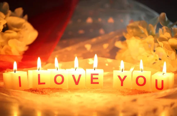 Candles with printed sign I LOVE YOU,on color fabric background — Stock Photo, Image