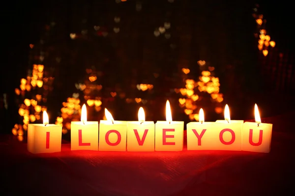 Velas con letrero impreso TE AMO, sobre fondo de luces borrosas — Foto de Stock