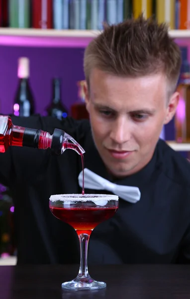 Portrait of handsome barman preparing cocktail, at bar — Stock Photo, Image