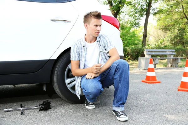 Man stuurprogramma problemen op road wiel wijzigenhaşlama yengeç salata yaprakları ve domates, ahşap masa, parlak zemin üzerine beyaz plaka üzerinde — Stockfoto