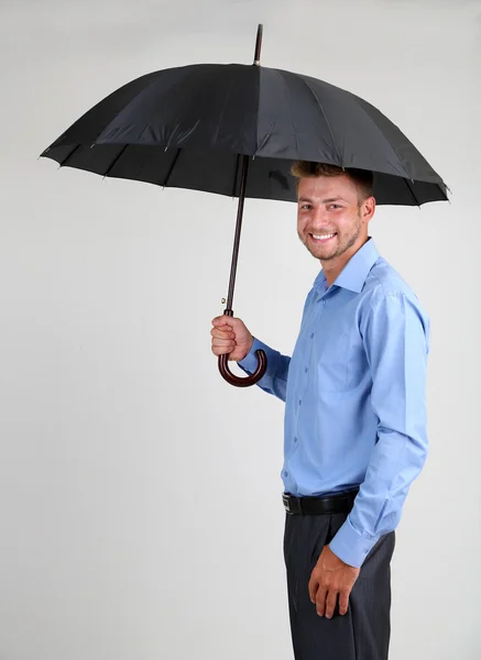 Empresario con paraguas. sobre fondo gris — Foto de Stock