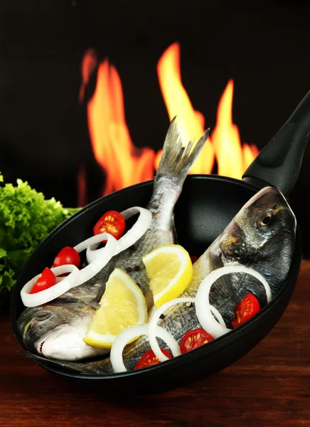 Dorado fish on table on fire background — Stock Photo, Image