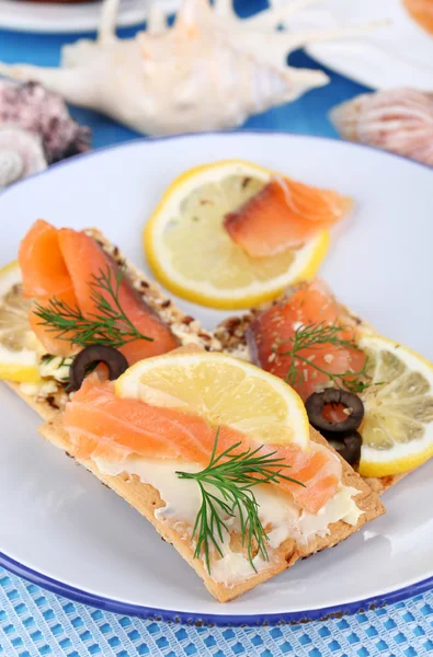 Zalm broodjes op plaat op houten tafel close-up — Stockfoto