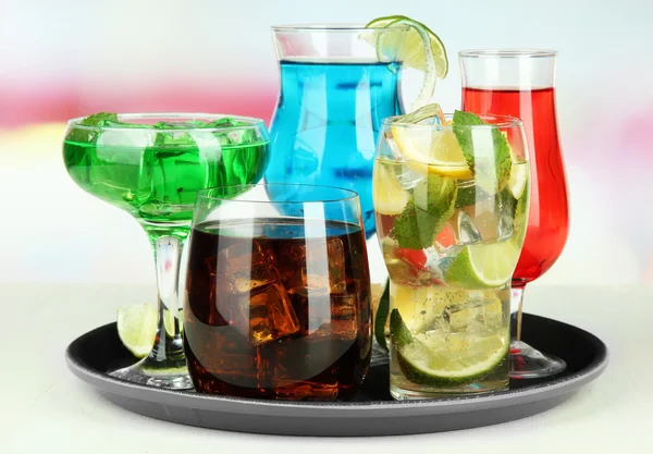 Many glasses of cocktails on tray on table, on bright background — Stock Photo, Image