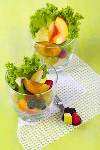 Salade de fruits en verre, sur fond bois — Photo