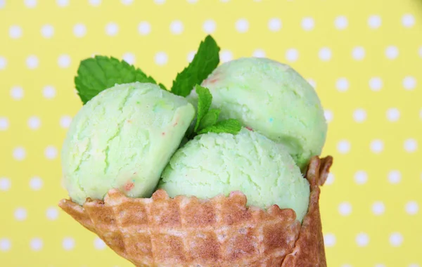 水玉の背景にワッフル コーンで食欲をそそるグリーン アイス クリーム — ストック写真