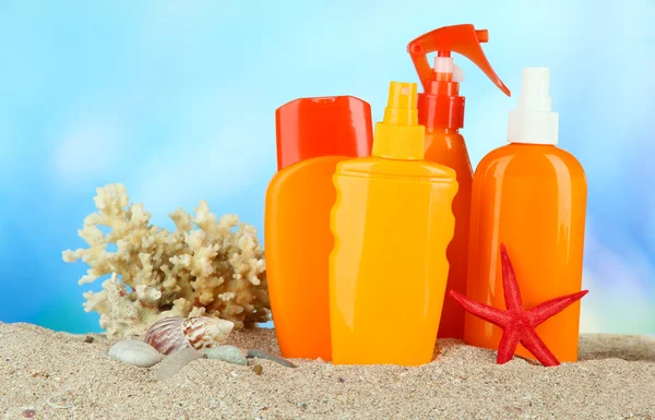 Bottles with suntan cream, on blue background — Stock Photo, Image