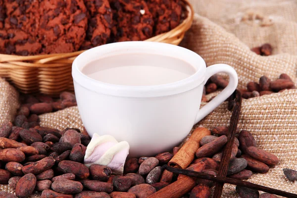Chocoladedrinks en cacaobonen op rouwgewaad achtergrond — Stockfoto