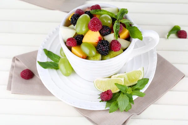 Ensalada de frutas en taza sobre mesa de madera —  Fotos de Stock
