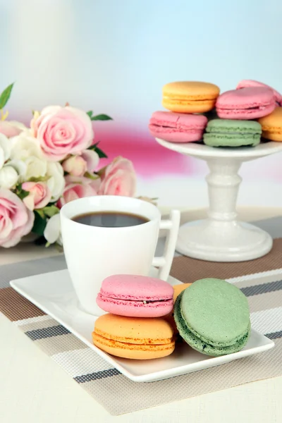 Café y macarrones sobre mesa sobre fondo claro —  Fotos de Stock