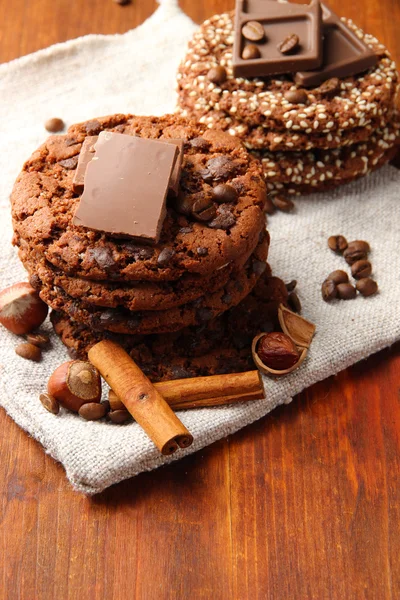 Homemade cookies with sesame seeds, chocolate, on wooden table, on sackcloth background — Stock Photo, Image