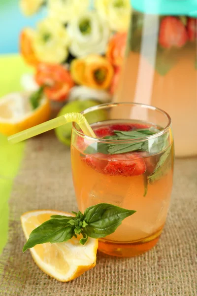 Limonada de albahaca con fresa en jarra y vidrio, sobre mesa de madera, sobre fondo brillante — Foto de Stock