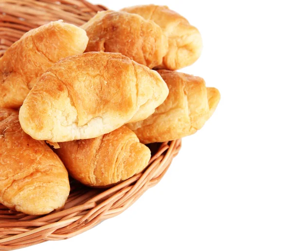 Croissants saborosos em esteira de vime isolado em branco — Fotografia de Stock