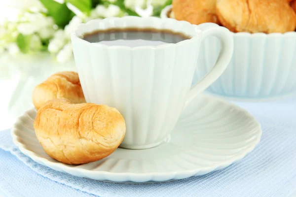 Tasty croissants and cup of coffee on table on white background — Stock Photo, Image