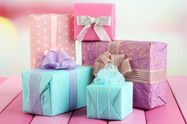 Hermosos regalos brillantes, sobre mesa de madera brillante — Foto de Stock