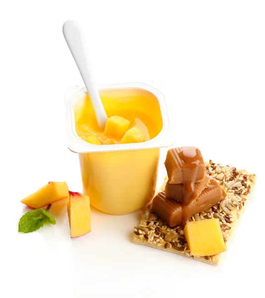 Smaczny jogurt z kawałkami owoców, ciastka i cukierki toffi na białym tle — Zdjęcie stockowe