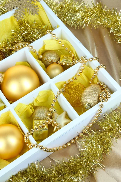 Brinquedos de Natal em caixa de madeira no fundo brilhante — Fotografia de Stock