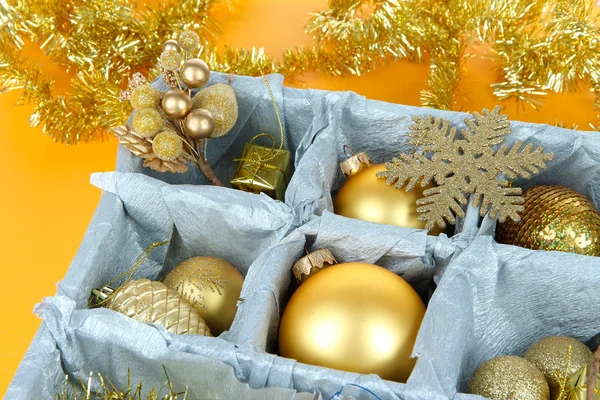 Christmas speelgoed in houten doos op gele achtergrond — Stockfoto