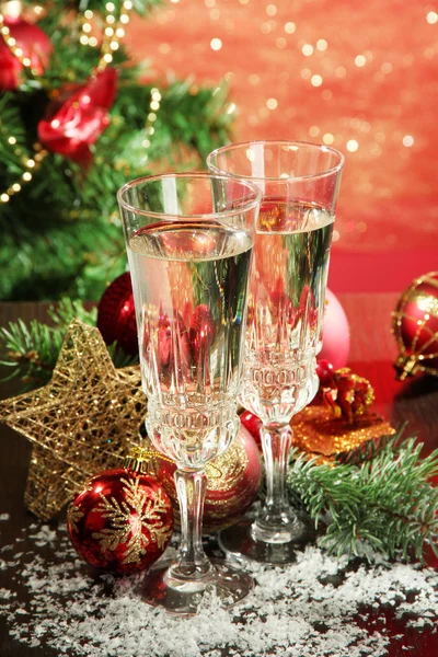 Yılbaşı süsleri ve parlak zemin üzerine iki şampanya bardağı kompozisyonu — Stok fotoğraf