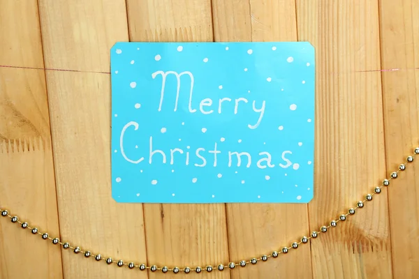 Вывеска со словами Счастливого Рождества на фоне деревянного стола крупным планом — стоковое фото