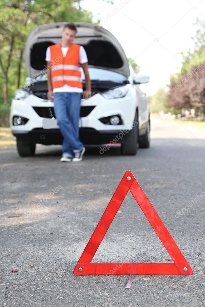 Broken down car with red warning triangle